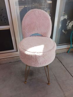 Cute pink vanity chair with storage under seat.