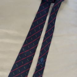 Gucci silk tie featuring a navy blue background emblems