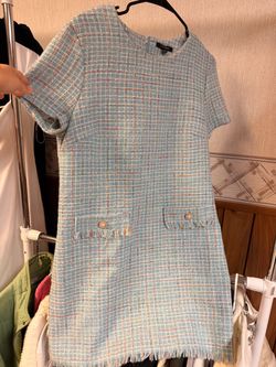 This City Studio Tweed Dress highlights a classic preppy silhouette with pearl-accented buttons and textured woven tweed.