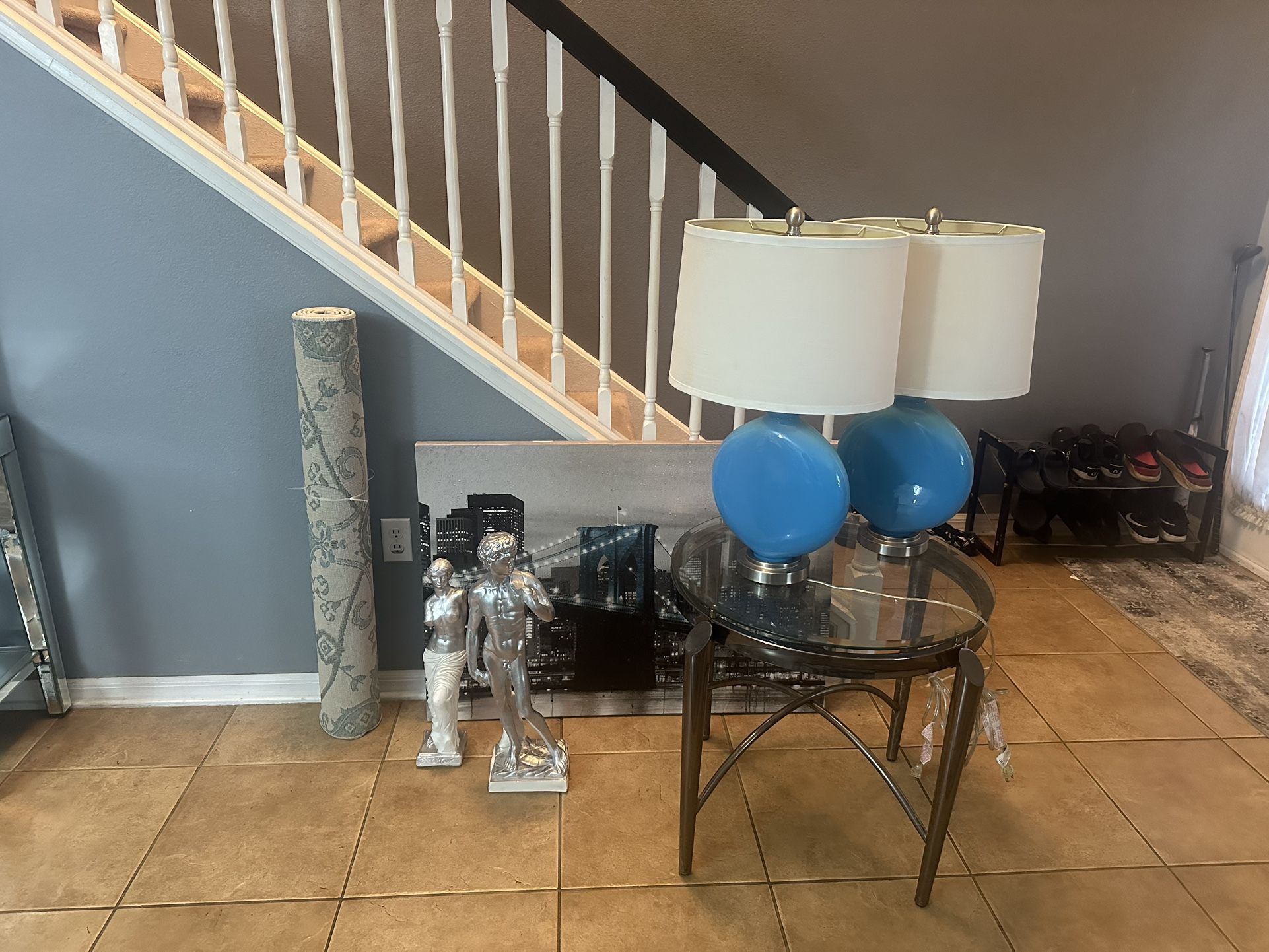 glass Crome end table, 2 teal lamps, 2 Greek Statues, City Canvas portrait and a rug 
