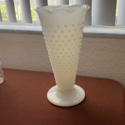 This is a piece of milk glass, specifically a hobnail vase.
