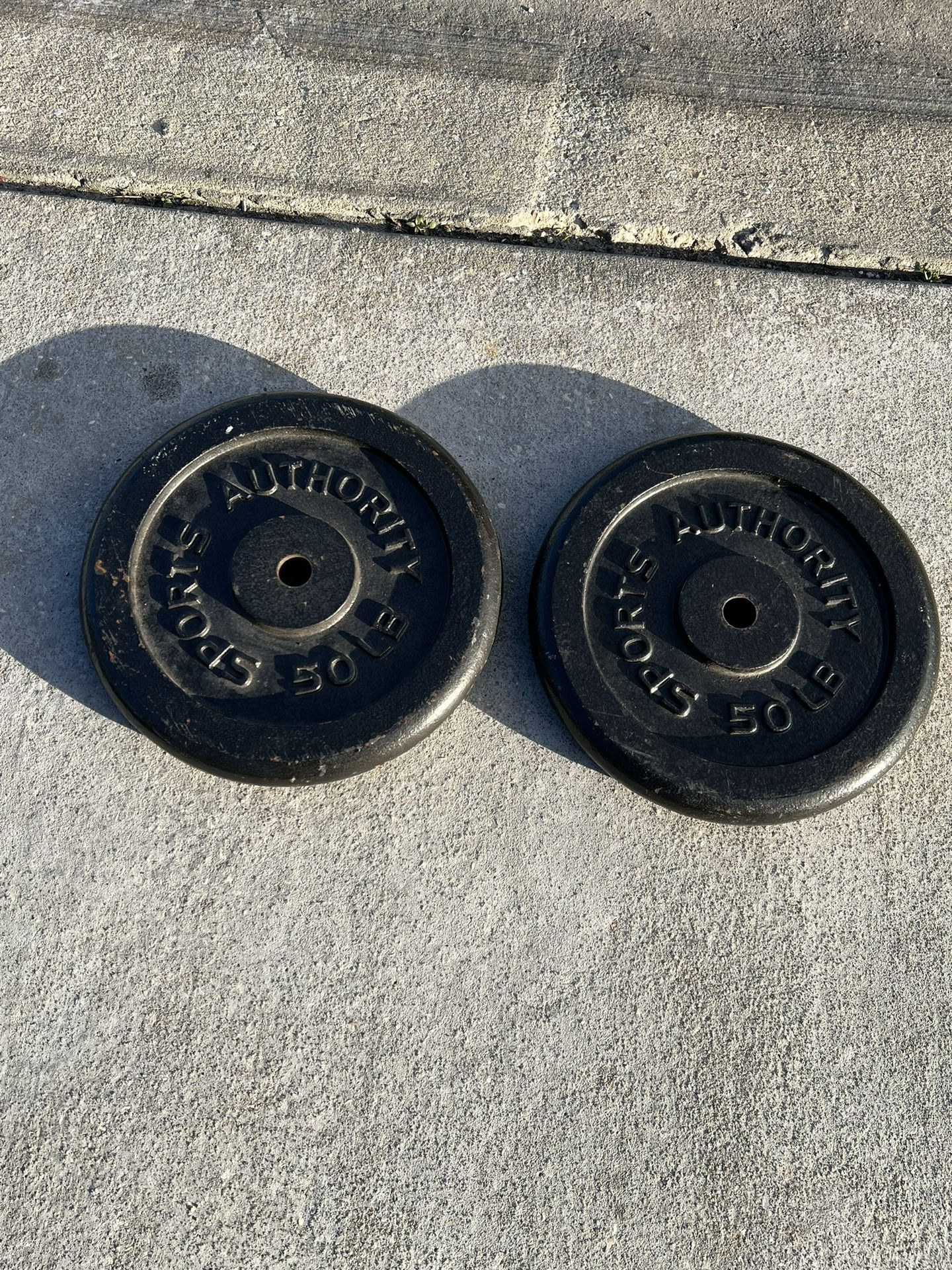 Standard Cast Iron Barbell Weight Plate(100lbs)SPORTS AUTHORITY *Single* pre owned in good condition with cosmetic blemishes from prior usage.