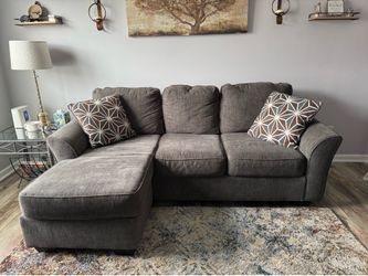 Gray couch with chaise lounge and 2 accent chairs.