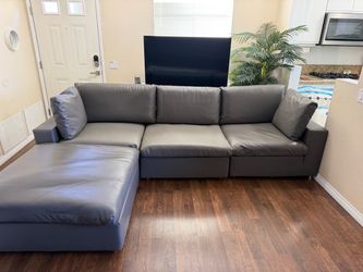 Gray vegan, faux leather sectional couch, sofa with adjustable foot ottoman