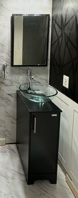 Black vanity with sink vessel and mirror