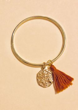 Gold bangle with charm and tassel