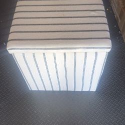 Esta es una caja puf a rayas que también funciona como taburete otomano, con una estructura de madera maciza y tela suave. 