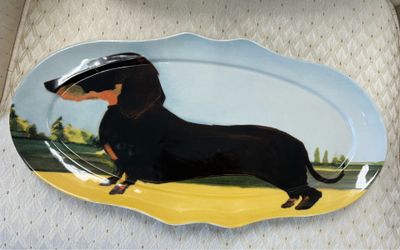 Sally Muir For Anthropologie Dog-A-Day Dachshund Oval Serving Platter. It measures approximately 16 3/4" × 8 1/2" X 3/4". New. There is a rough area o