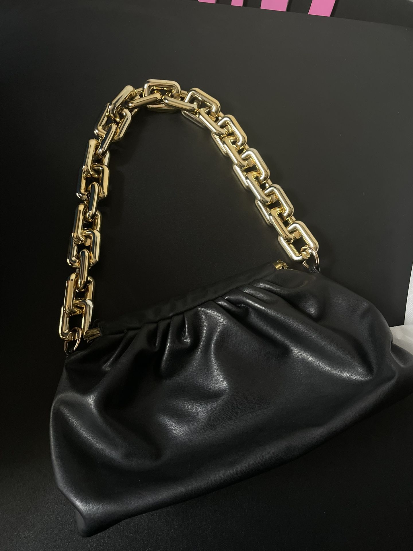 Black handbag with a gold link handle