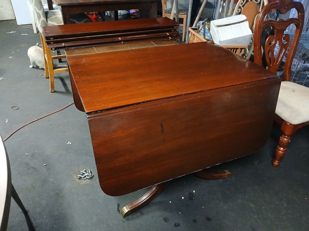 Antique Wood Table With Metal Feet And Drop Leaf On Each End To Make It Smaller And 4 Leafs To Extend The Middle To Make It Longer 