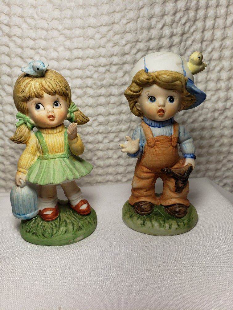 Vintage Home Interiors Boy & Girl figurines . Boy measures 5" T X 2 1/2" L X 2"W . Girl measures 5"T X 2 1/4" L X 2"W . Boy has a chipped finger shown
