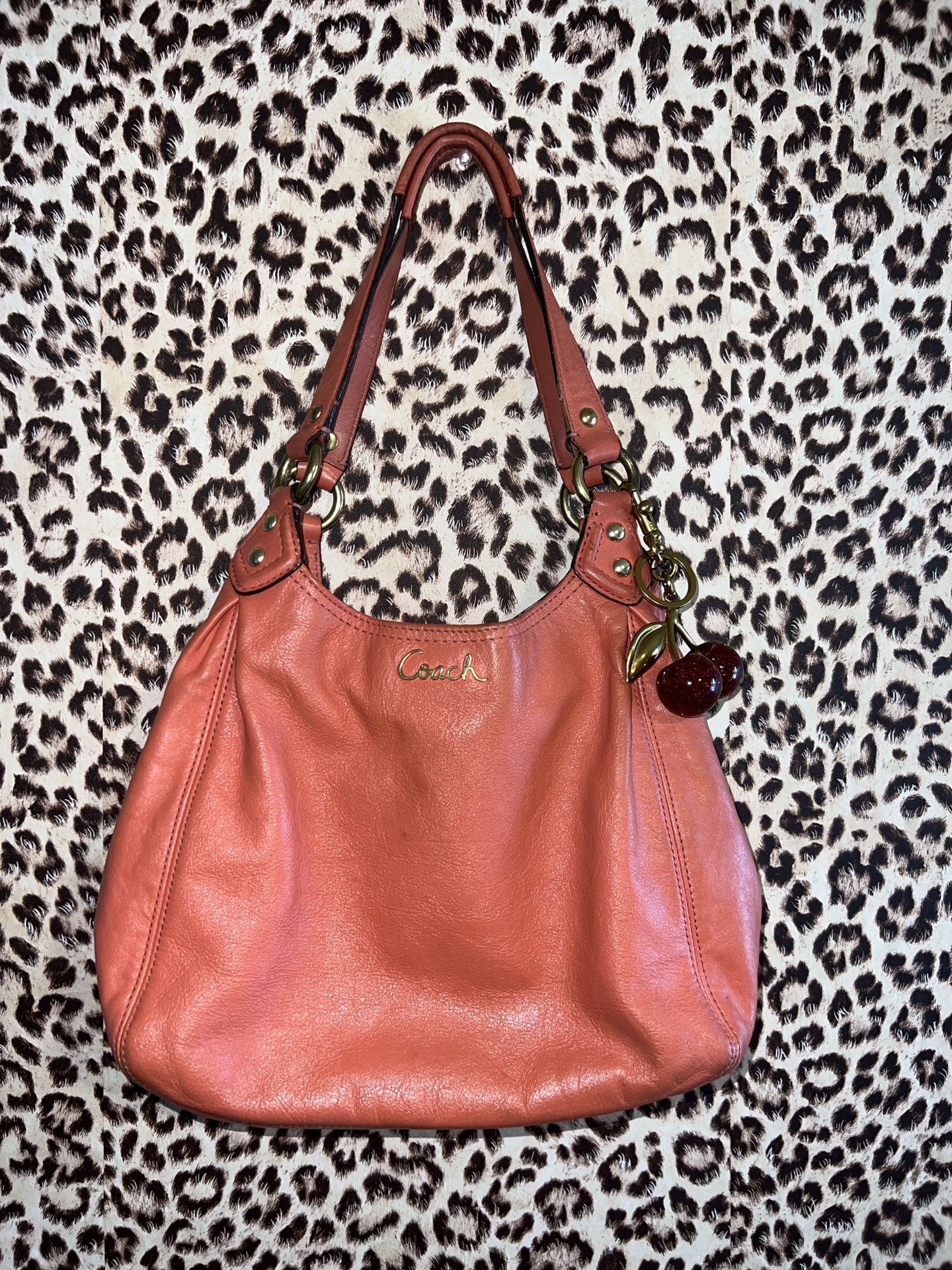 Coral Coach leather shoulder bag with gold hardware and cherry