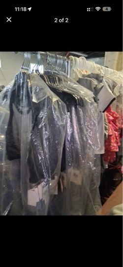 Brand new clothes with the tag on them all different styles and colors and sizes.