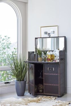 Old fashioned bar cabinet wrapped in dark brown leatherette.