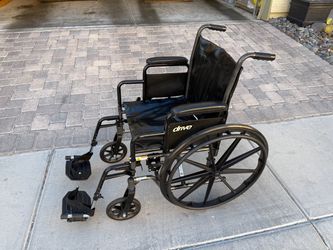 Drive Medical Silver Sport Lightweight Folding Wheelchair with Padded Armrests and swing-away footrests.