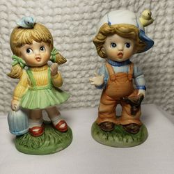 Vintage Home Interiors Boy & Girl figurines . Boy measures 5" T X 2 1/2" L X 2"W . Girl measures 5"T X 2 1/4" L X 2"W . Boy has a chipped finger shown