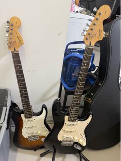 Sunburst Squier Strat and Black Squier Strat electric guitars