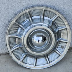 Two 57 cadillac hubcaps