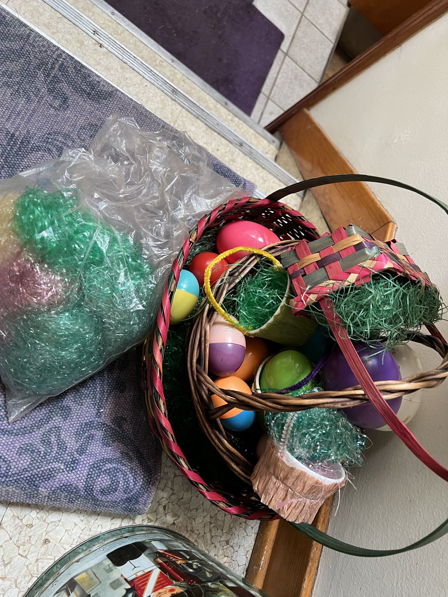 Easter Baskets Colored Eggs  And A Bag Of Different Colored Grasses 