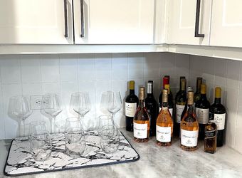 Español: Copas de vino y vasos de vidrio con botellas de vino. English: Wine Glasses, Drinking Glasses, and Wine Bottles.