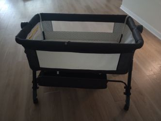 grey 3-in-1 bedside bassinet and sleeper with wheels.