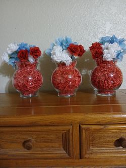 3 BRAND NEW RED, WHITE AND BLUE DECORATIONS WITH FLOWERS IN GLASS VASES