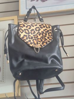 Dune London backpack features a distinct leopard-print calf hair flap and gold-tone chain detailing.