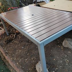 Outdoor patio table. Large 71" x 40". Metal with umbrella hole. Brown & grey. Great condition