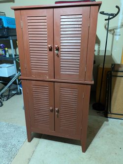 Brown sturdy cabinet with 2 doors on top and 2 doors on bottom