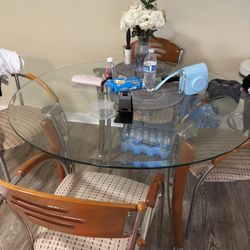 A round glass table with four chairs