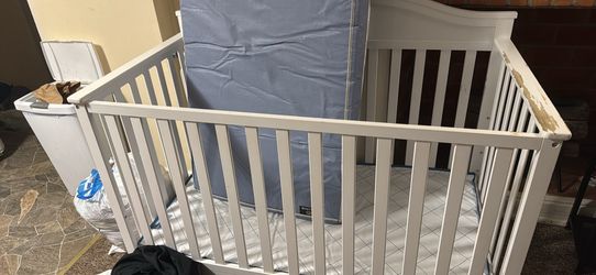 A Crib And Two Mattresses