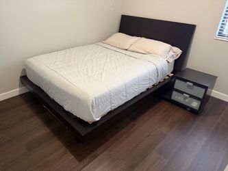 Brown queen bed with mattress and mattress protector