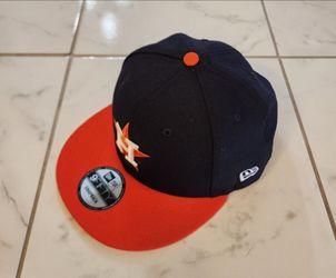 New Era 9FIFTY Houston Astros snapback hat featuring a navy blue crown and a contrast orange visor.