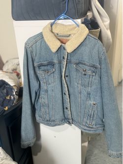 classic light wash Levi's denim jacket featuring a cozy white sherpa lining.