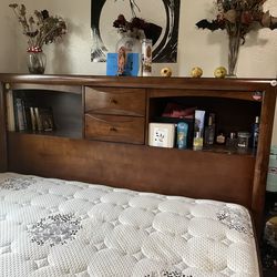 Wooden queen bed frame with lots of storage on the side with drawers and on top too
