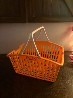 orange plastic mini shopping basket with dual white folding handles, commonly used as a toy or small storage organizer