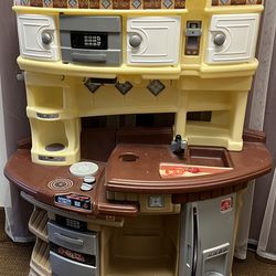 Toy play kitchen  w microwave, oven, sink, and fridge. Doors and drawers open and close. Incomplete