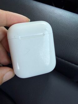 Apple headphones, charging case and headphones on the left ear