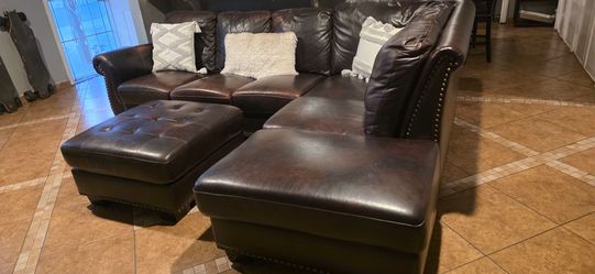 Brown leather sectional sofa used but super comfortable with ottoman ..  Perfect for a starter couch or man cave some leather cracks between 2 seats