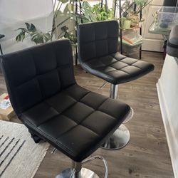 2 black adjustable barstools with silver hardware