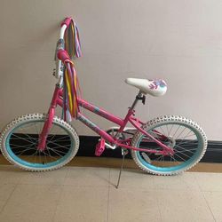 This is a Huffy 20" Sea Star Kids' Bike in pink.  It features a deep pink steel frame with coordinating aqua blue wheel rims and white tires.  The bik