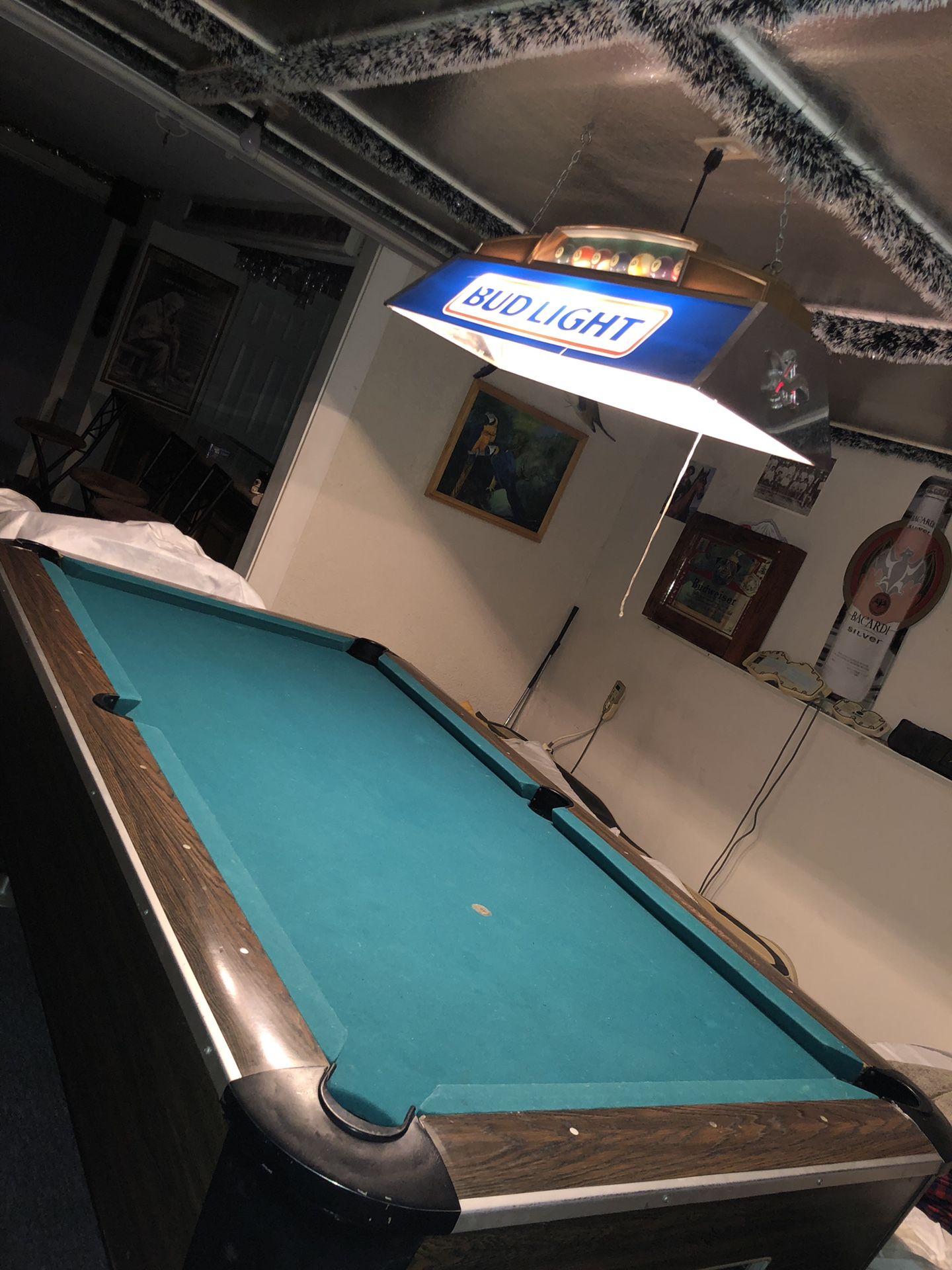 Pool table, budlight light, and cue sticks