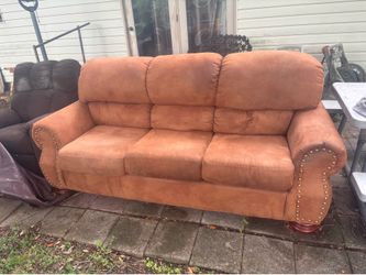 Brown suede couch with wood footing.