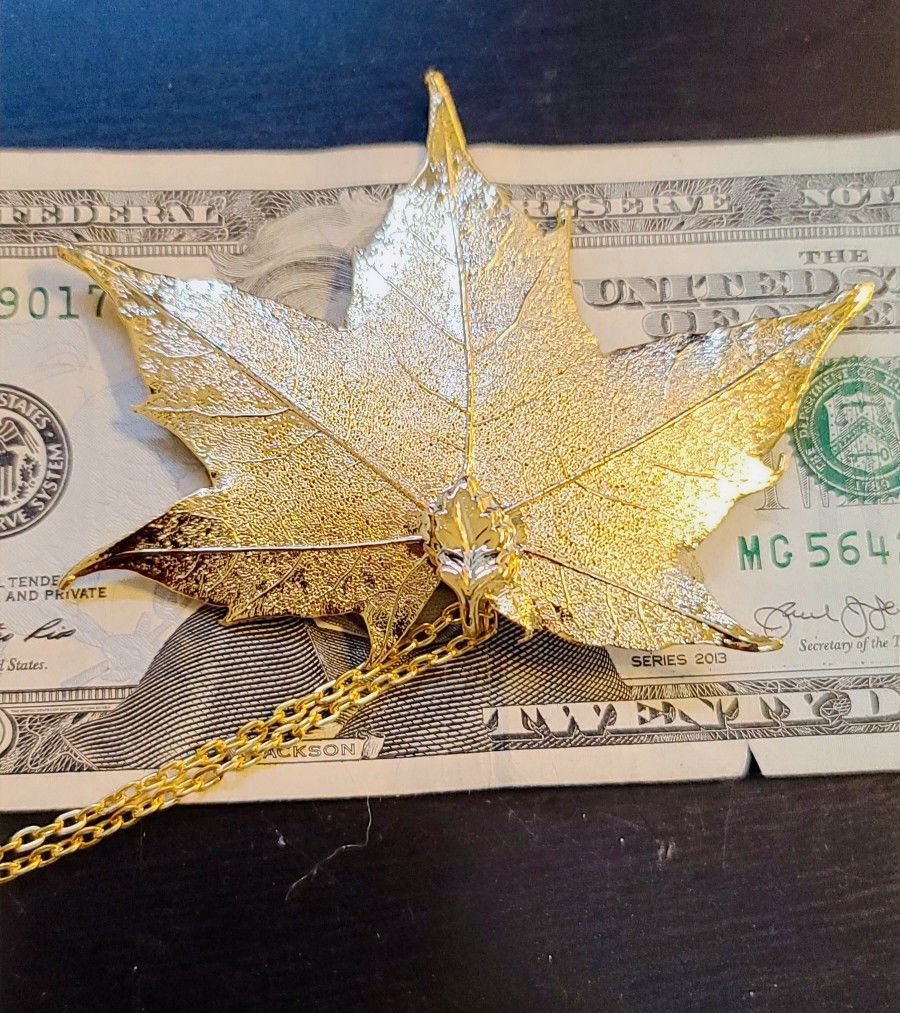 24k Gold, Real Maple Leaf Coated in Gold. Brand new, never worn. Comes with a 24-in chain.