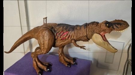 Mattel Jurassic World Extreme Damage Tyrannosaurus Rex Action Figure, Detailed Jurassic World T-Rex action figure is brown with black and red accents.