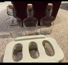 3 old dressing bottles and wooden stand