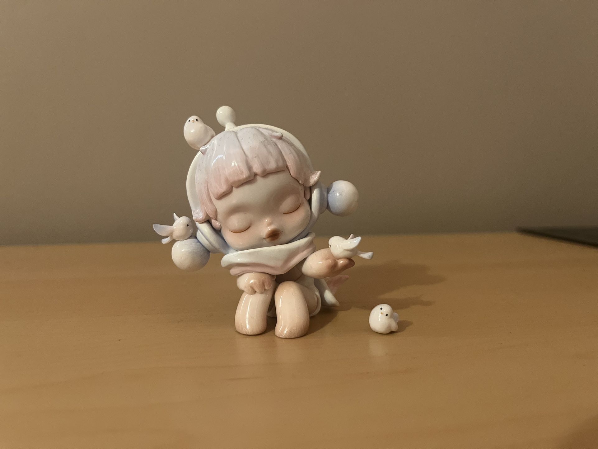 The product is the "Chirping" figure from the POP MART SKULLPANDA The Warmth Series.