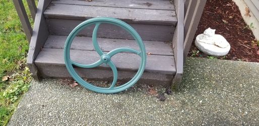 Large industrial wheel. Great for decorating or yard art. Possibly a wheelbarrow wheel.
