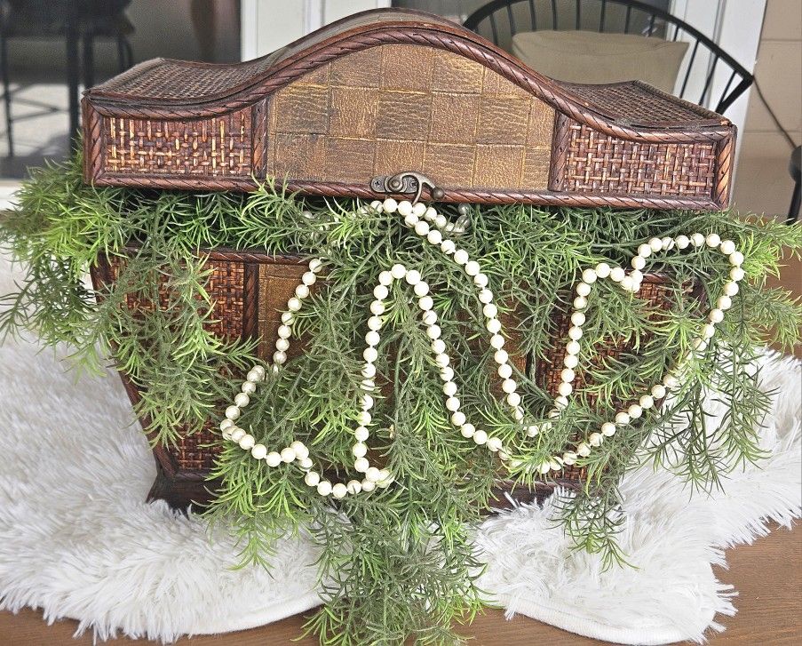 Antique wooden chest with artificial plant and pearls spilling out