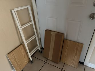 Three wooden shelves on a metal base with wheels. New! Packaging included